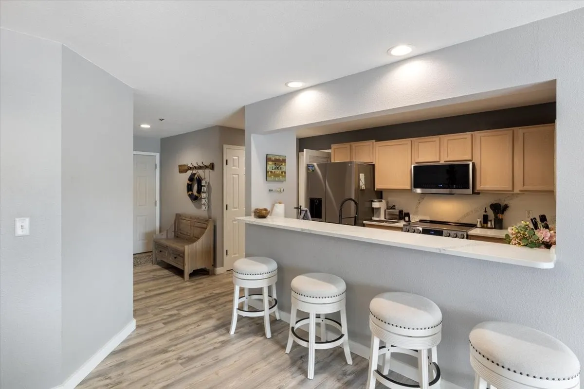 A stylish, updated kitchen with a central island, bar stools, modern appliances, and tasteful décor. The space invites shared culinary experiences, casual dining, and friendly gatherings, reflecting the potential for gourmet meals and entertaining.
