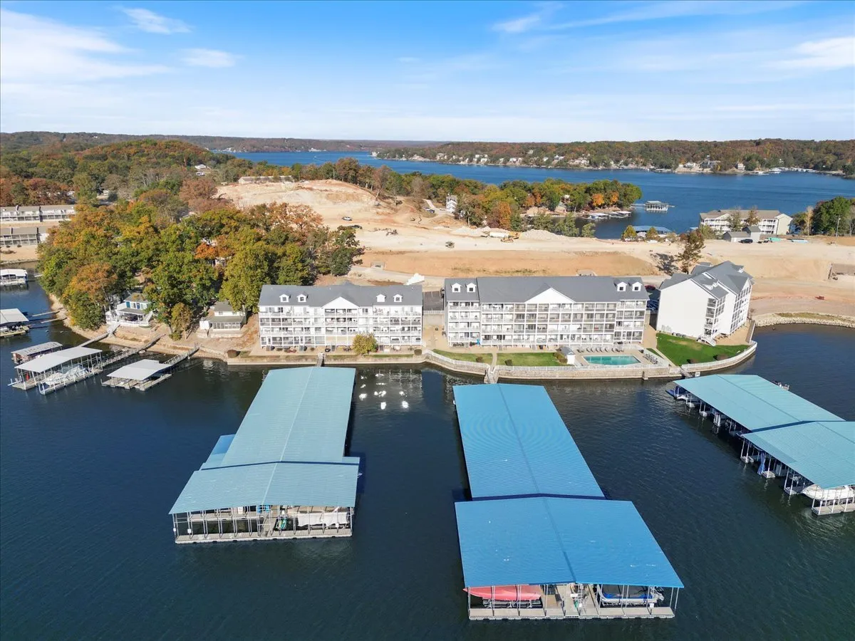 This exterior image features waterfront buildings, boat docks, and the natural surroundings of the lake. Several boats are visible at the docks, with the water stretching out into the background, creating a vibrant lakeside scene perfect for boating and water activities.