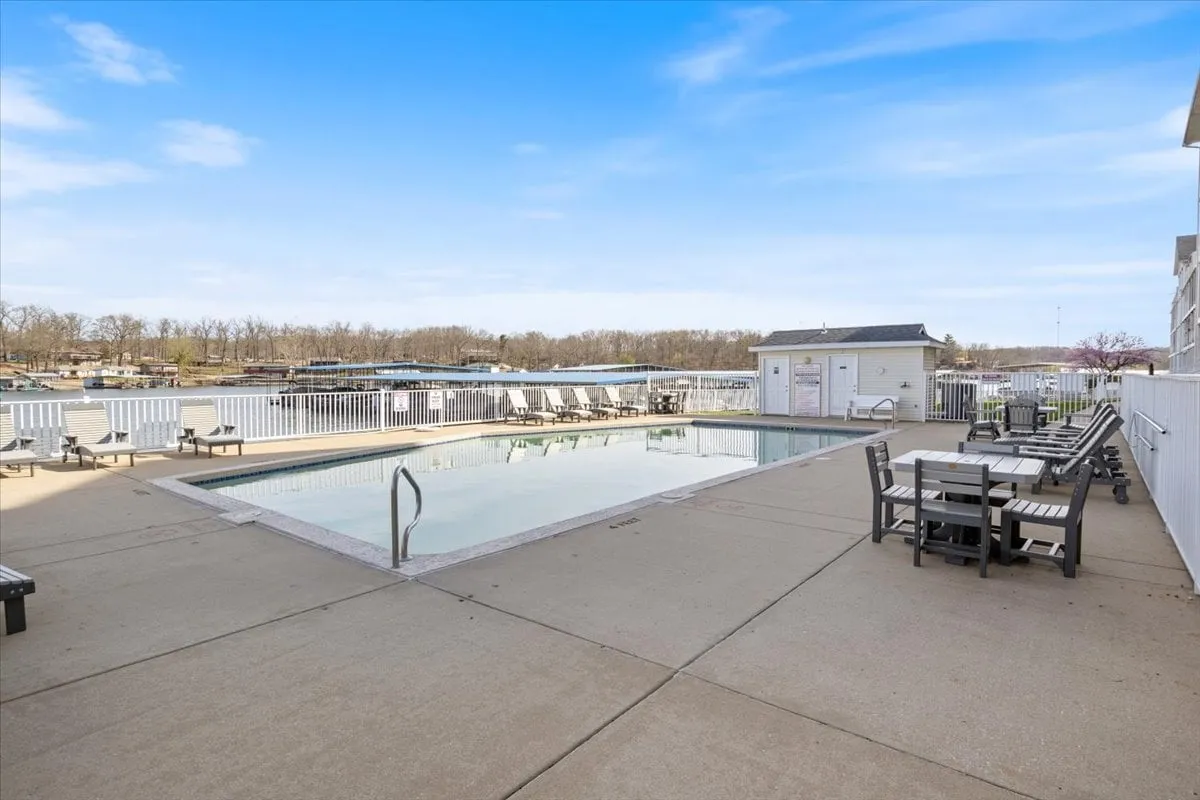 A spacious outdoor area featuring a heated swimming pool, lounge chairs, dining tables, and direct waterfront views. The inviting space is perfect for rejuvenating breaks, socializing, or simply soaking up the sun.